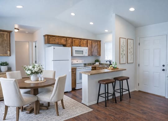A kitchen with a table and chairs in the middle of the room.