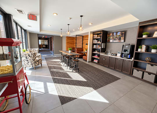 A red food cart is in the foreground of a modern lobby area.