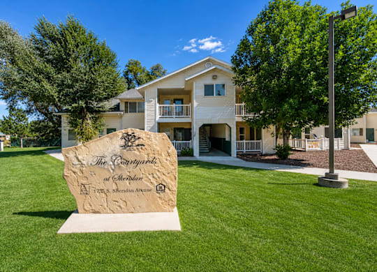 A large stone sign in front of a building that says "The Parkway".