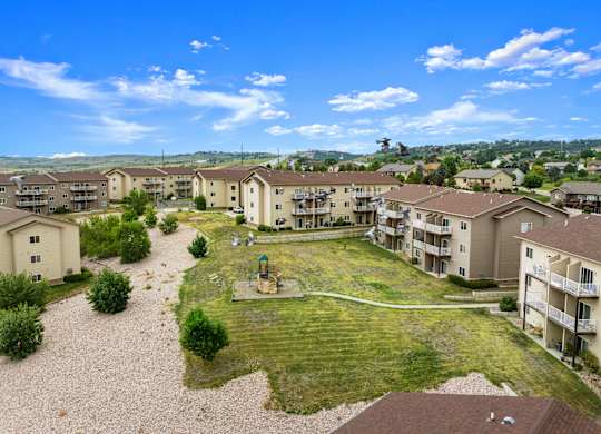 A sunny day at a residential complex with apartments and a playground.