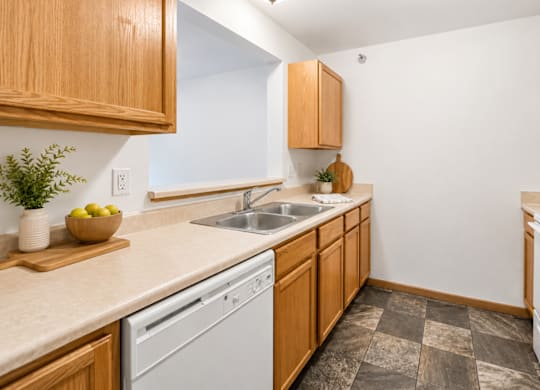 A kitchen with wooden cabinets and a white dishwasher.