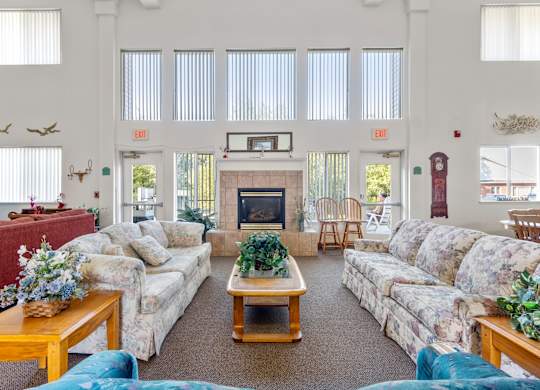 A living room with a fireplace and a TV on the wall.