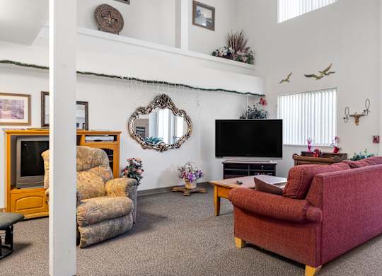 A living room with a red couch and a television.