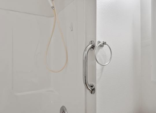 A white door with a silver handle and a white cord hanging from it.