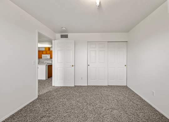 A room with a grey carpet and white walls.