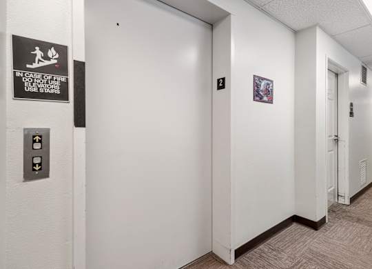 A hallway with a sign on the wall that says "In case of fire do not use stairs".