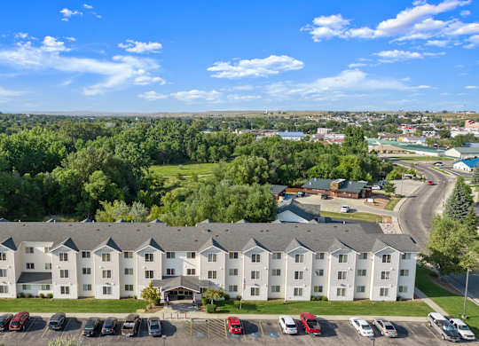 A large white building with a parking lot in front of it.