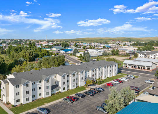 A large white building with a parking lot in front of it.