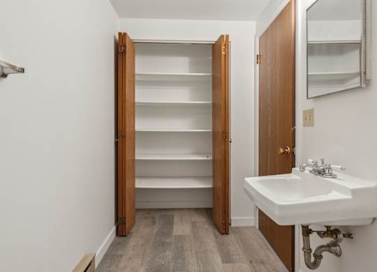A white sink is installed under a mirror in a small room.