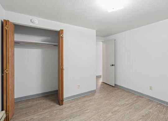 A room with a white wall and a wooden door.
