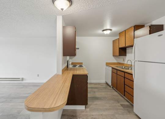 A kitchen with a white refrigerator and wooden countertops.