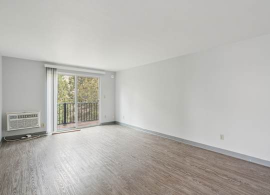 A room with a sliding glass door leading to a balcony.