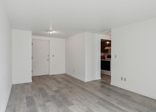 A room with a white door and a grey floor.