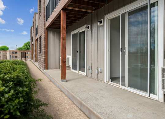 A building with a concrete walkway and glass doors.