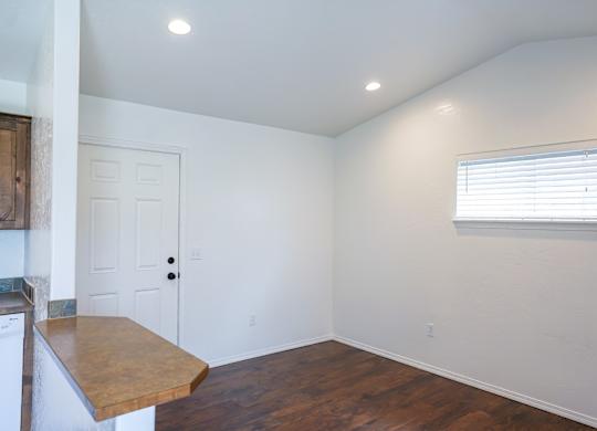 A room with a door, a window with blinds, and a washing machine.