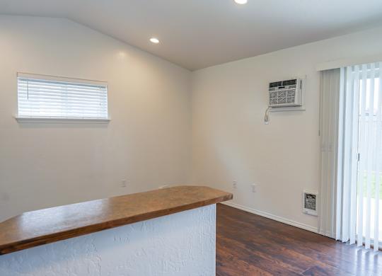A room with a window and a wooden counter.