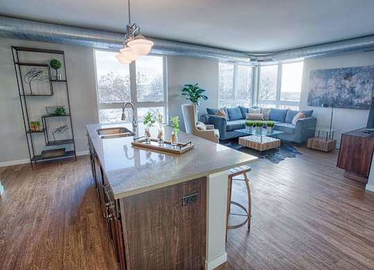 A kitchen with a wooden island and a dining area with a blue couch.