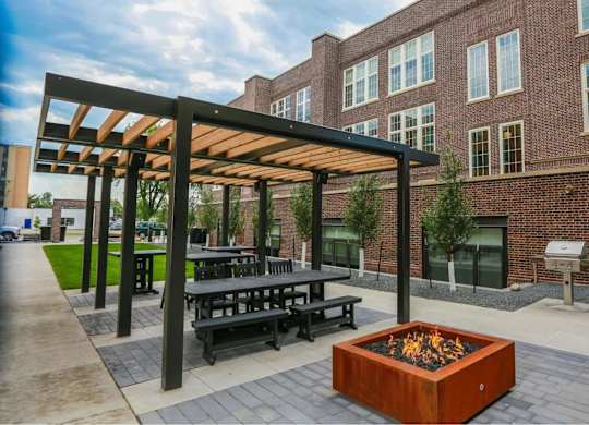 A modern outdoor seating area with a fire pit in the center.