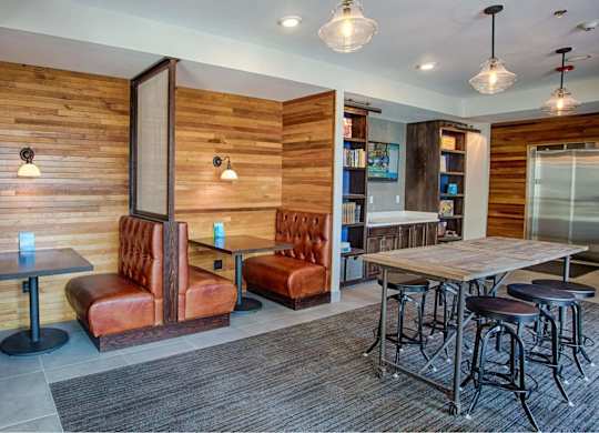 A room with a wooden wall and a table with chairs.