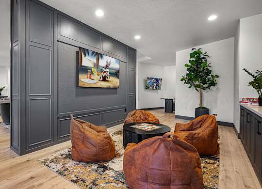 A living room with brown bean bag chairs and a painting on the wall.