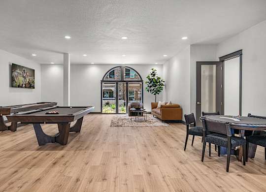 A room with a pool table and a couch.