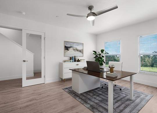 an office with a large window and a desk with a laptop
