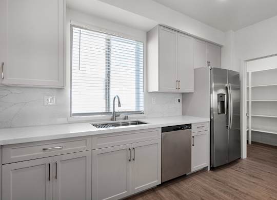a renovated kitchen with white cabinets and stainless steel appliances