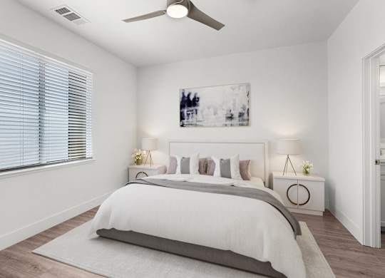 a white bedroom with a bed and a ceiling fan