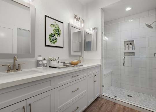 a white bathroom with a shower and a sink