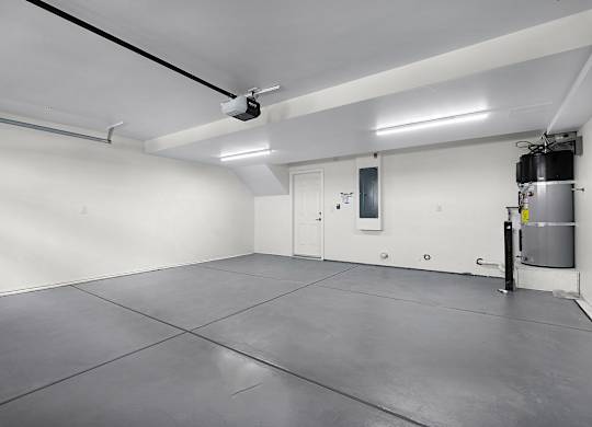 the interior of a white room with a water heater in the corner
