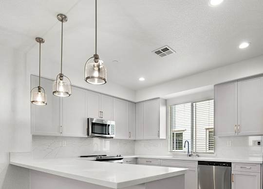 a kitchen with white cabinets and a white counter top