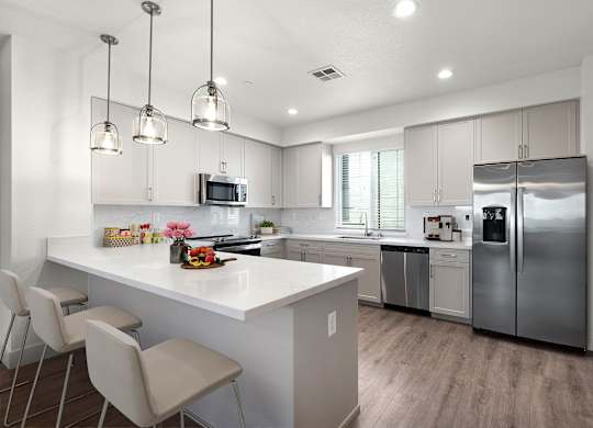 a kitchen with a large island and stainless steel appliances