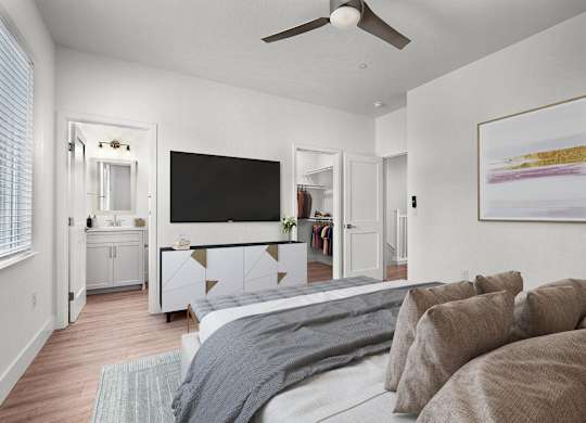 a bedroom with a large bed and a ceiling fan