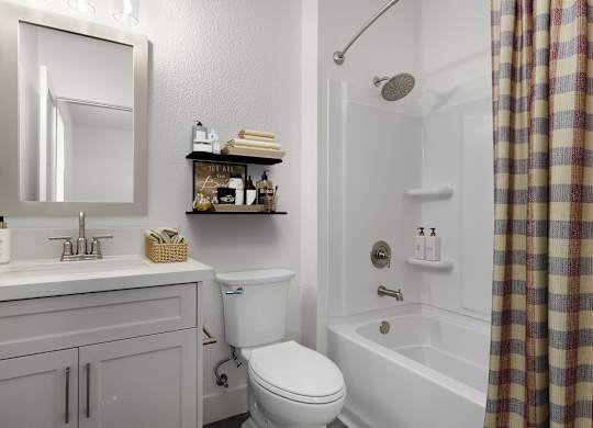 a bathroom with a toilet sink and tub and a mirror