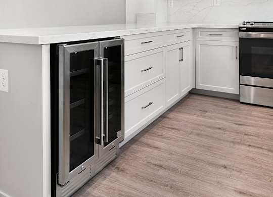a white kitchen with stainless steel appliances and white cabinets
