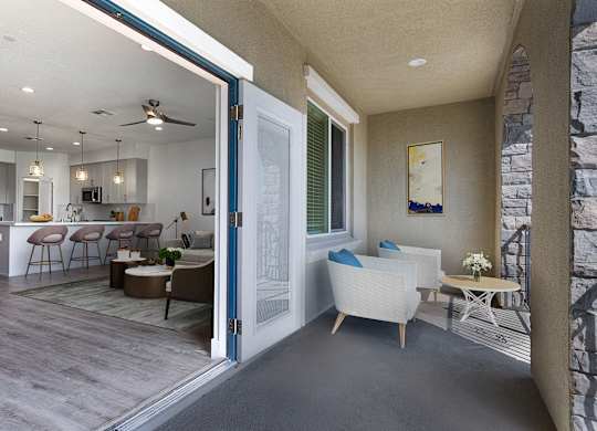 a view of a living room and kitchen from a patio door