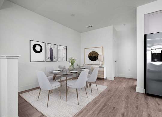 a dining room with a round table and white chairs