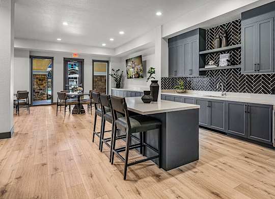 A kitchen with a large island and bar stools.