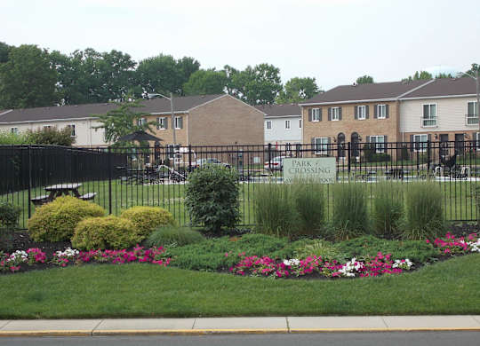 A park with a sign that says "park crossing" is in front of a building.