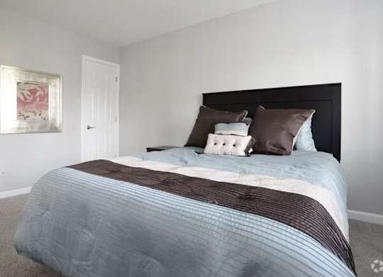 A bed with a striped comforter and two pillows is in the image.