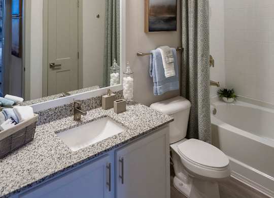 Full bathroom with granite vanity and tub at Ciel Luxury Apartments, Jacksonville