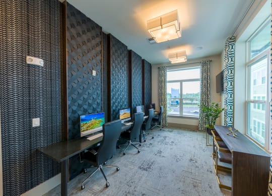 Business center with workstations and patterned accent wall at Ciel Luxury Apartments, Jacksonville, FL