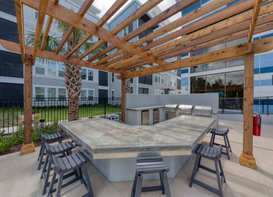 Outdoor kitchen with grills under wooden pergola at Ciel Luxury Apartments, Jacksonville, FL 32246