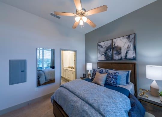Bedroom with blue linens and artwork at Ciel Luxury Apartments, Jacksonville, FL