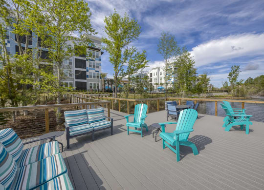 Waterfront deck with colorful seating and lake view at Ciel Luxury Apartments, Jacksonville, FL