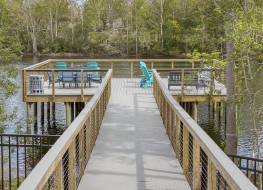 Waterfront boardwalk leading to lakeside deck with seating at Ciel Luxury Apartments, Jacksonville