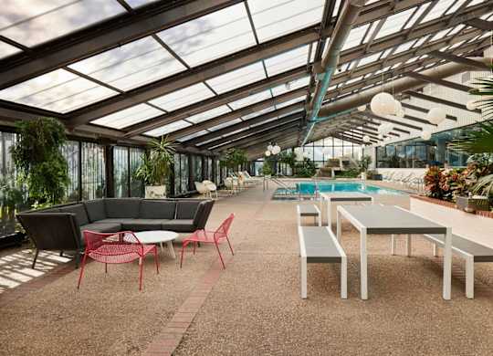 A patio with a table and chairs is covered by a glass roof.