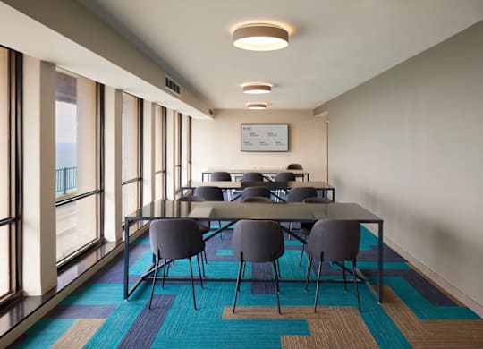 A conference room with a long table and chairs.