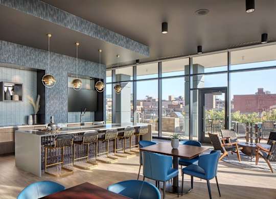 A modern kitchen and dining area with blue chairs and a wooden table.