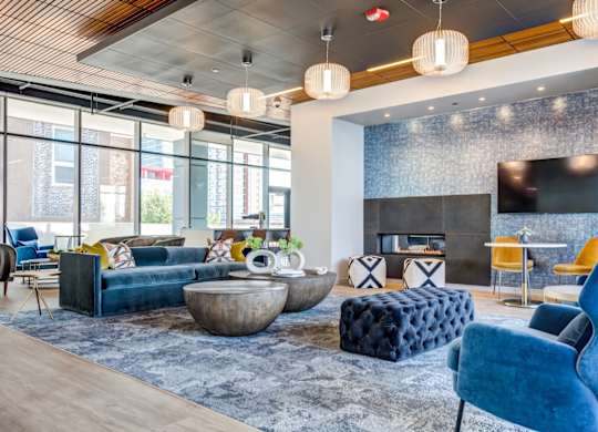 A modern living room with a fireplace and a blue chair.